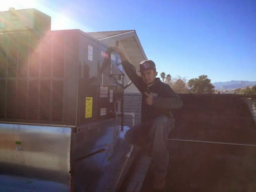 HVAC technician performing Air Duct Repair on a rooftop unit in Pleasant View